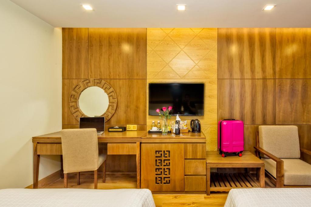 A room workspace beside a wood media cabinet, with a mirror and lounge chair.