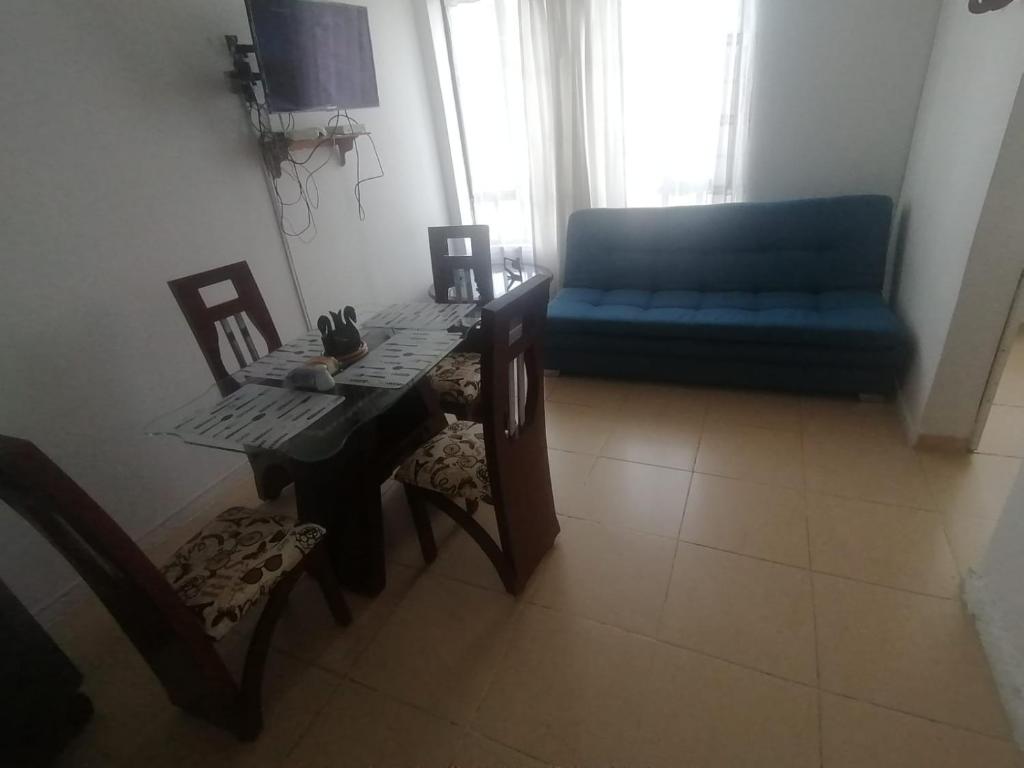 uma sala de estar com uma mesa e um sofá azul em Casa Rionegro em Bogotá