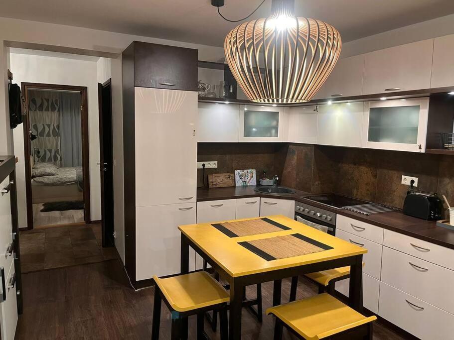 uma cozinha com uma mesa e cadeiras amarelas em Kahe magamistoaga võtmeteta ja eraldi sissepääsuga esimesel korrusel korter, sobilik peredele, lemmikloomad lubatud em Tartu