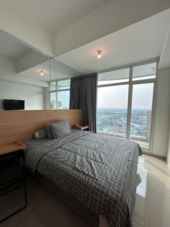 1 dormitorio con cama y ventana grande en QnM Rooms at Treepark City, en Tjikokol