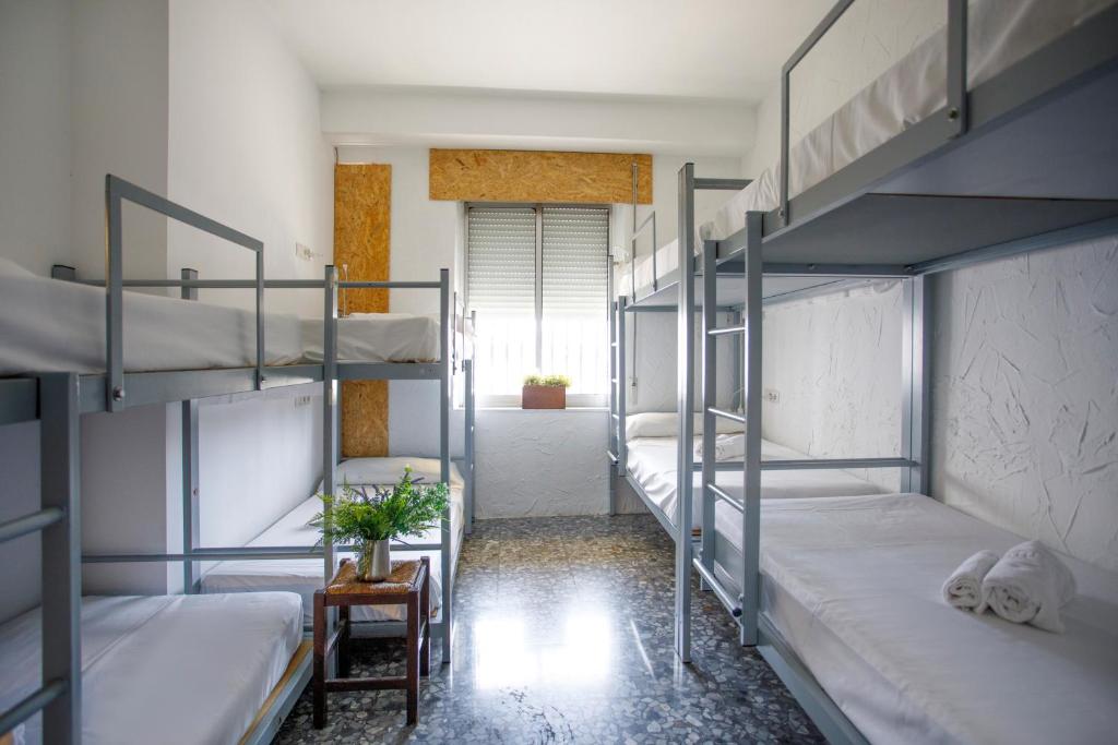 a room with four bunk beds and a hallway at Italica Hostel in Santiponce