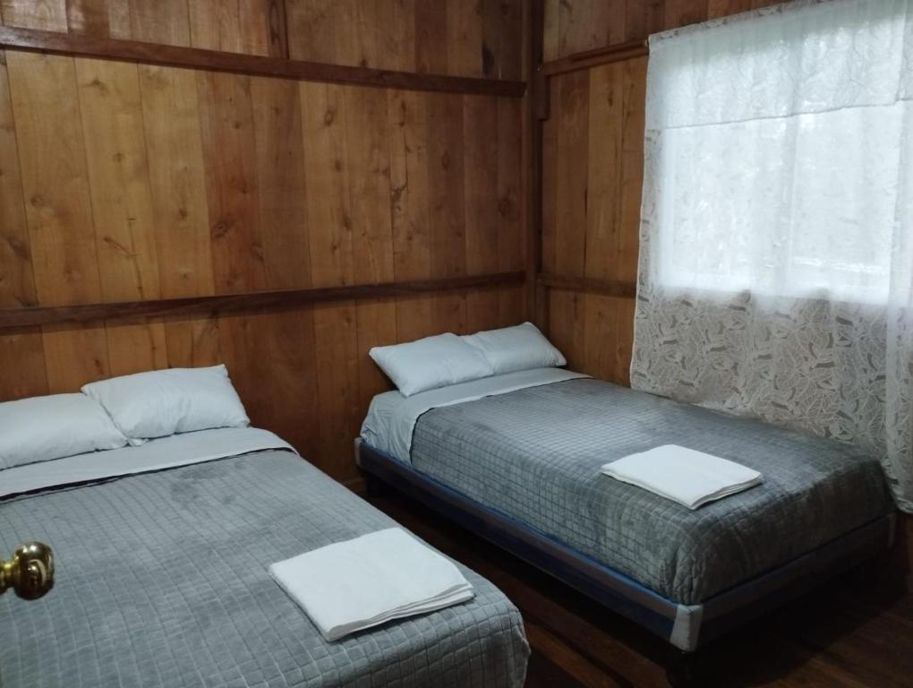 MINDO SUM في ميندو: سريرين في غرفة بجدران خشبية ونافذة