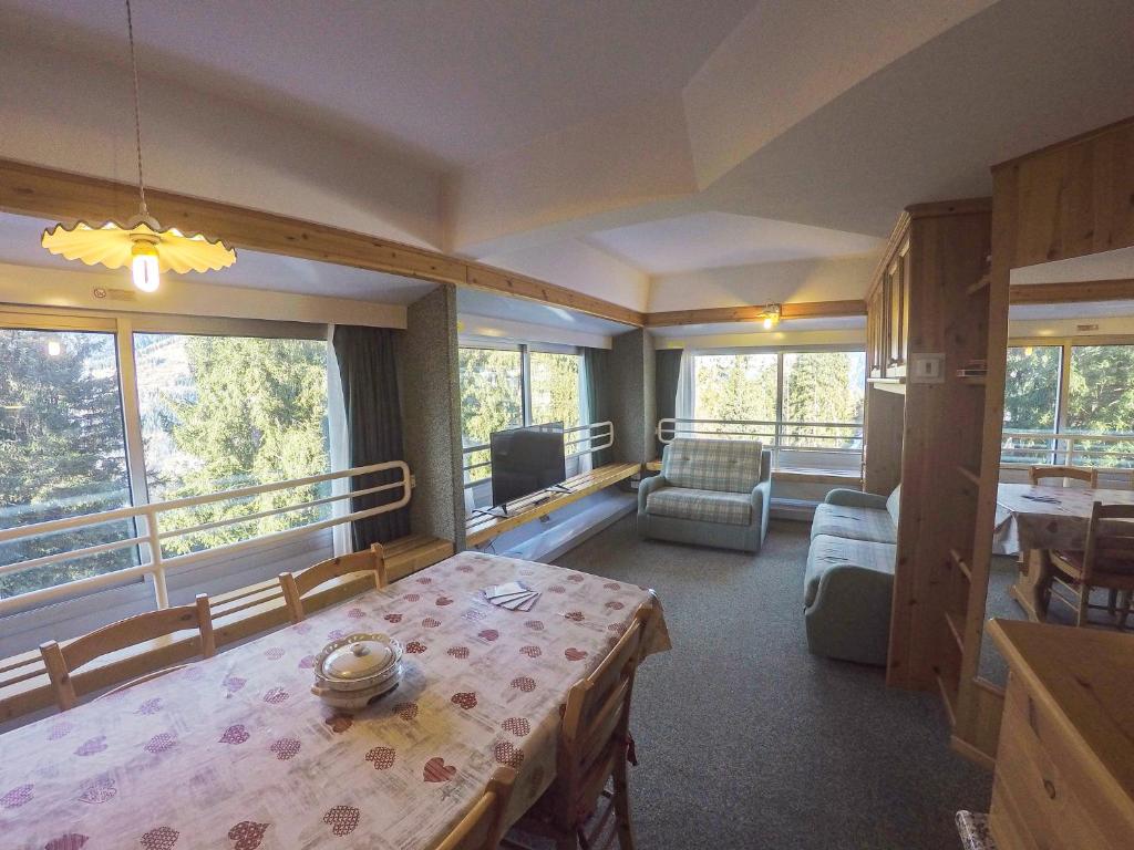 una habitación con mesa y sillas y una habitación con balcón en Appartamento Solaria a Marilleva 1400 en Marilleva