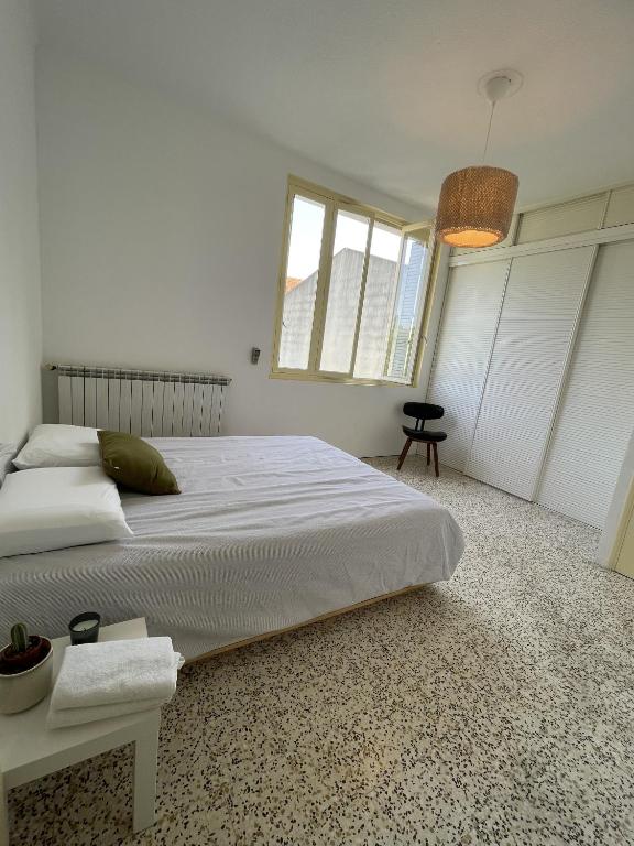 a white bedroom with a large bed and a window at Chambre au calme en cœur de ville in Cavaillon
