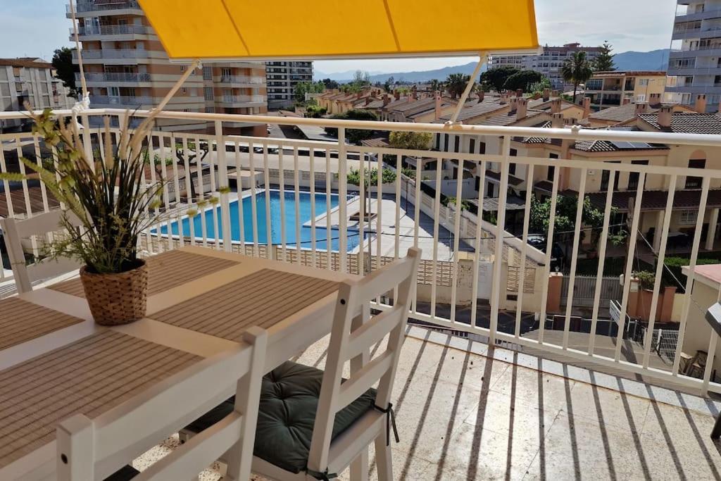 balcón con sombrilla y piscina en Apartamento de playa en paseo marítimo en Benicàssim