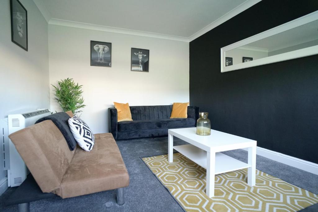 ein Wohnzimmer mit einem Sofa und einem Tisch in der Unterkunft Keir Hardie House in Larkhall