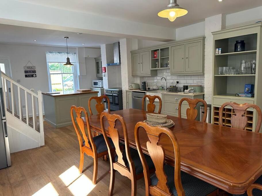 a kitchen and dining room with a wooden table and chairs at Home in Dartmouth, Devon with Private Parking in Dartmouth