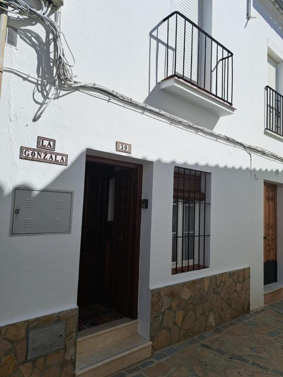 Edificio blanco con puerta y balcón en La Gonzala, en Zahara de la Sierra