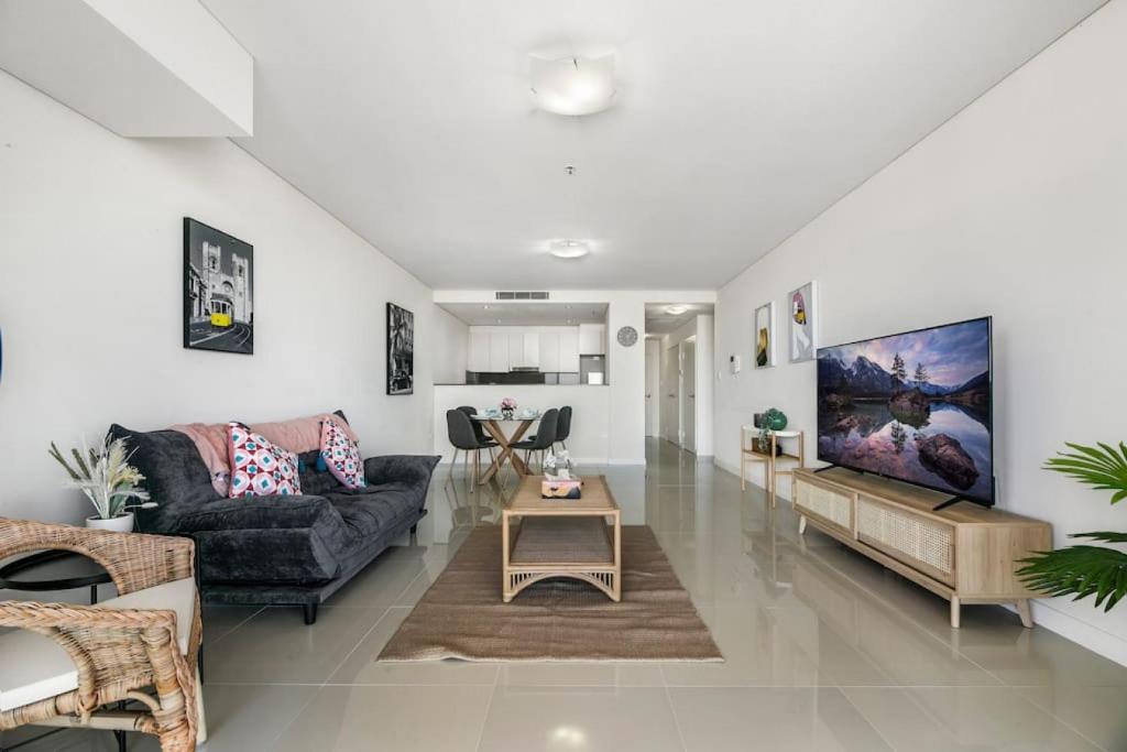 a living room with a couch and a table at Spacious 2 beds Apt near Airport in Sydney