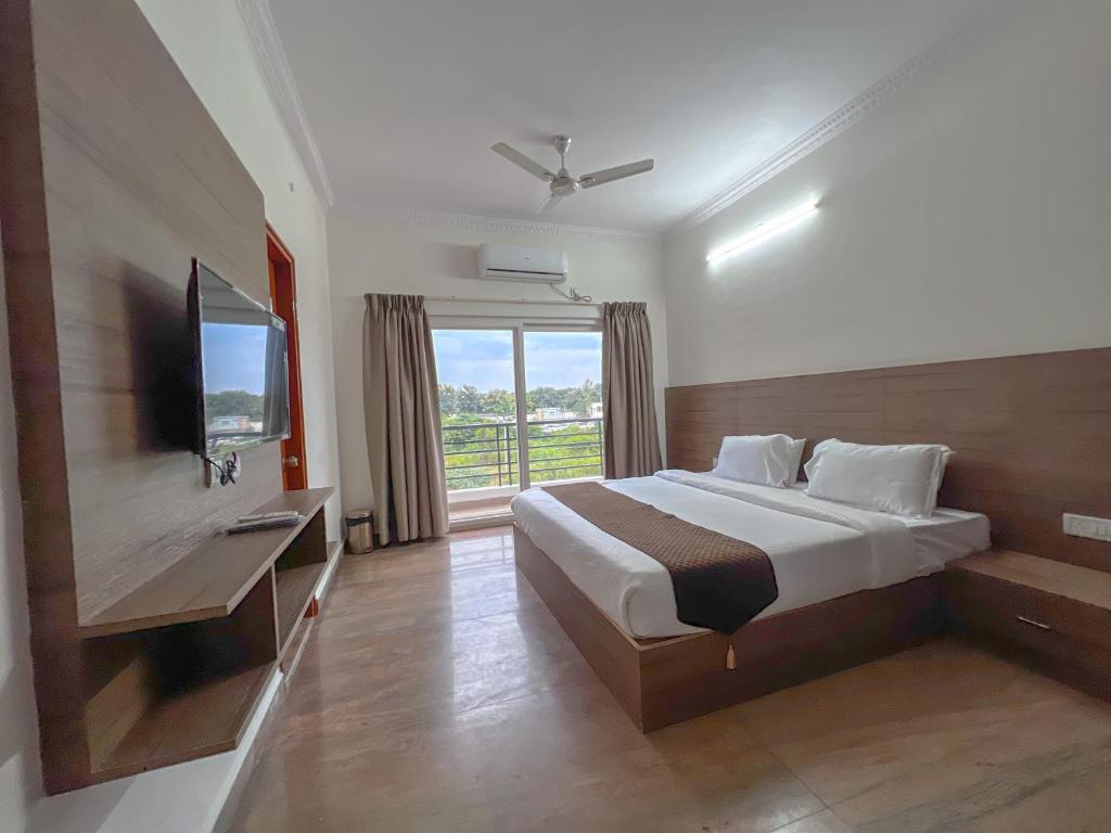 a hotel room with a bed and a television at Hotel Elite by Agira- Spacious Apartments with Balcony in Yelahanka