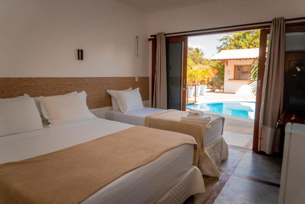 a bedroom with two beds and a swimming pool at Pousada Morada do Sol in Camocim