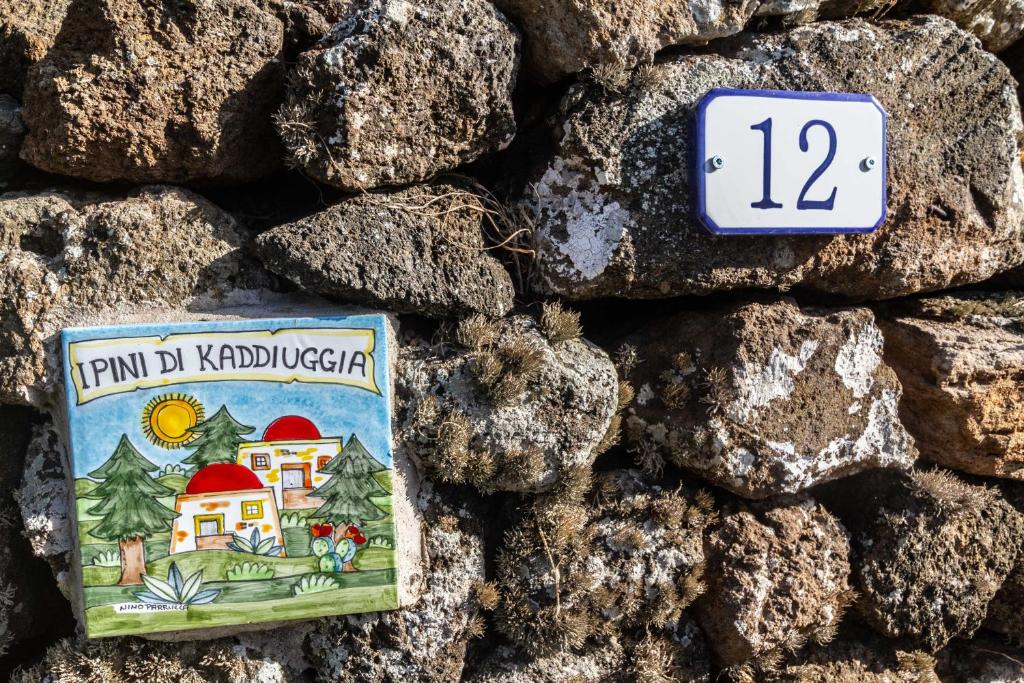 una pequeña señal en una pared de piedra en Dammuso i Pini di Kaddiuggia (CIR19081014C224053) & Dammuso di Mena (CIR 19081014C224052, en Pantelleria