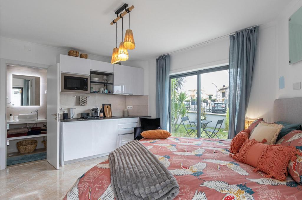 Cet appartement comprend une chambre avec un lit et une cuisine avec un balcon. dans l'établissement Nazare Oasis Suites and Retreats, à Nazaré