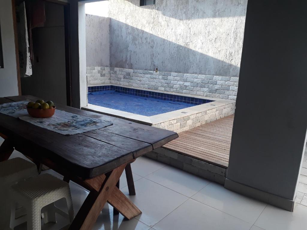 a plunge pool with a table and a wooden deck at Casa do Beto in Pirenópolis