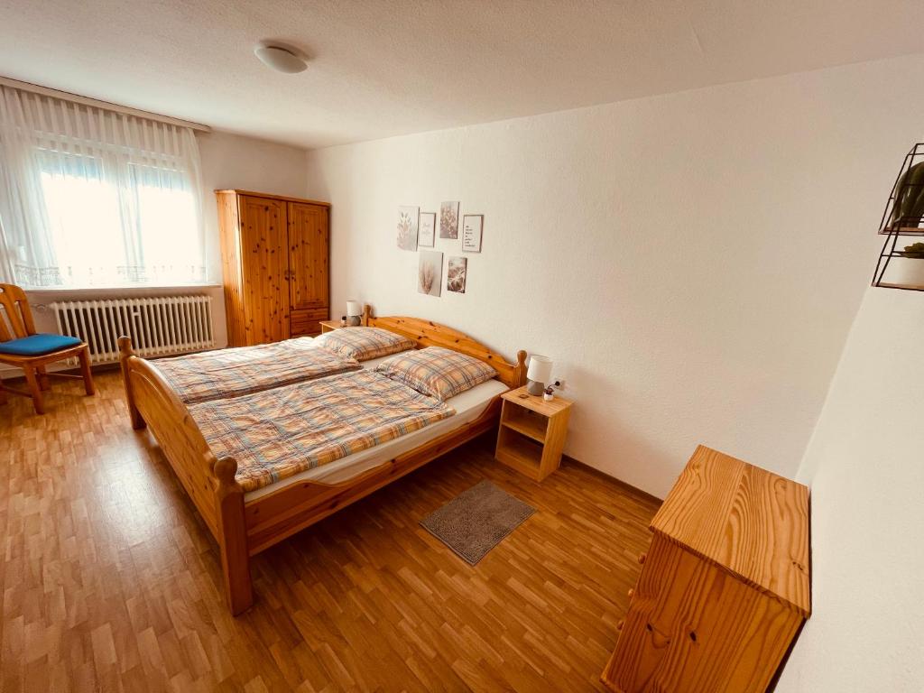 een slaapkamer met een bed en een houten vloer bij Moselferienhaus Porten in Ellenz-Poltersdorf