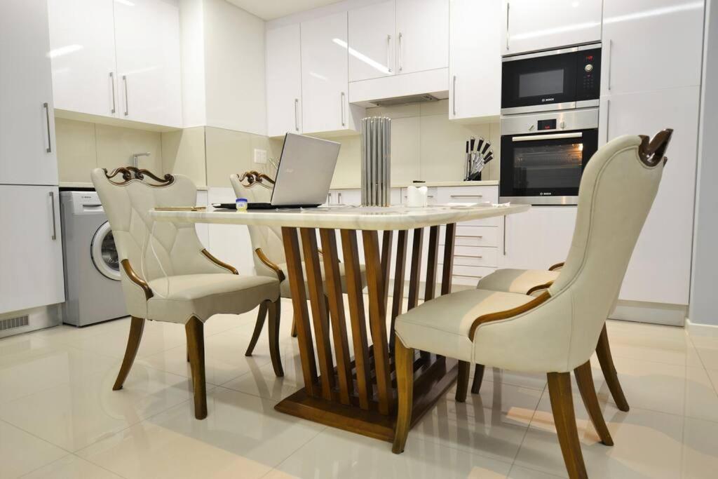 a kitchen with a table and chairs with a laptop on it at Skyview Apartments in Gaborone
