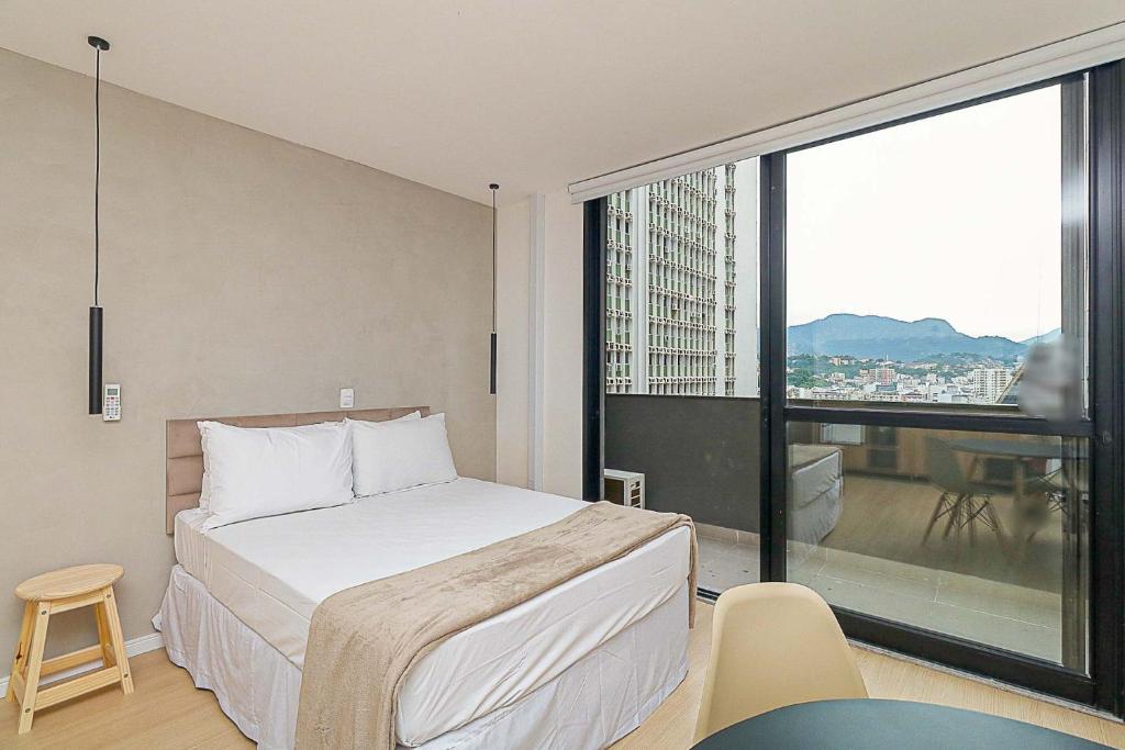 una camera d'albergo con un letto e una grande finestra di 360 Rio Santos Dumont a Rio de Janeiro