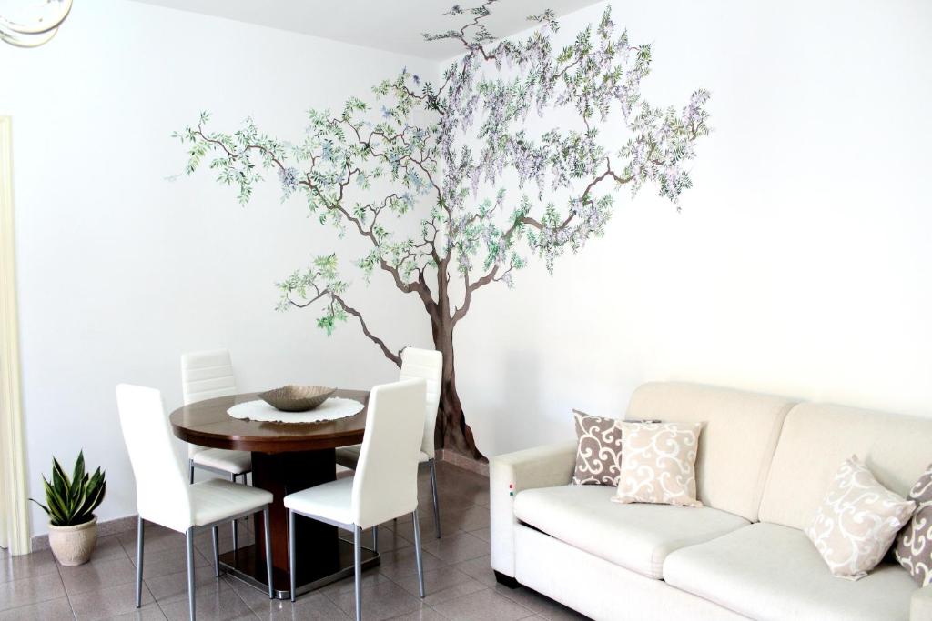 a dining room with a tree mural on the wall at Uno Spettacolo Della Natura in San Lucido