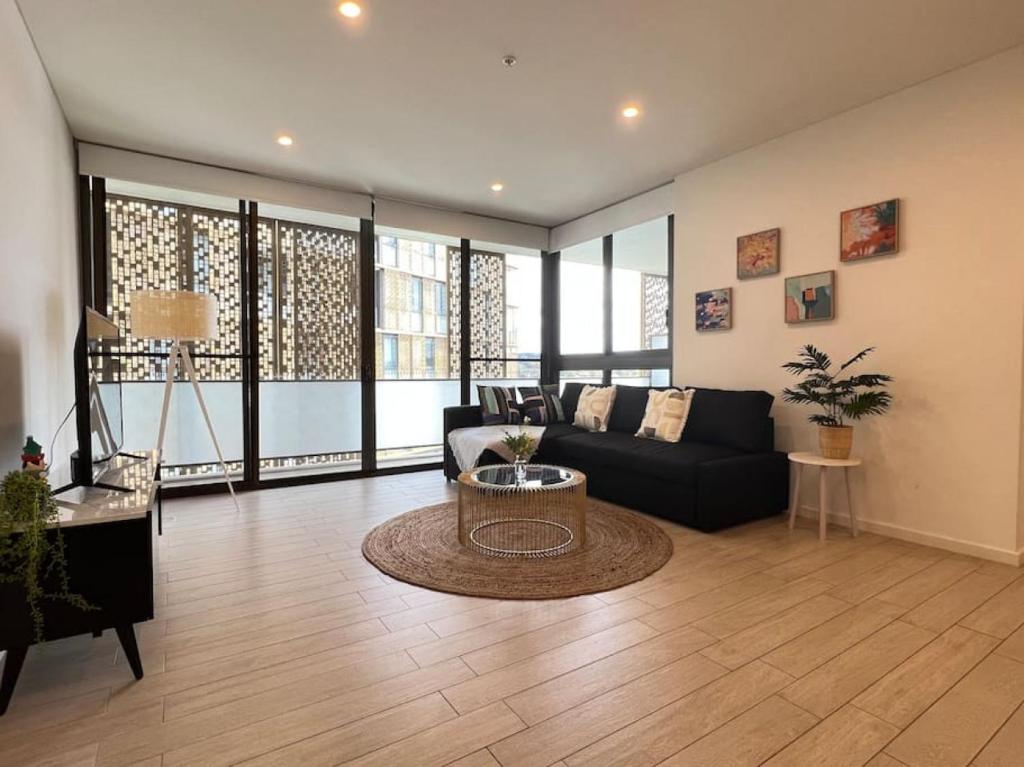 a living room with a couch and a table at Luxury 2 bedroom APT in Wentworth Point in Sydney