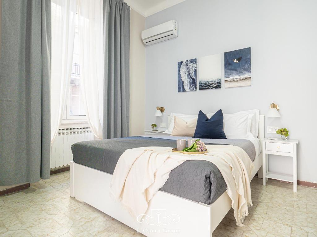a white bedroom with a large bed and a window at Casa MaNa - L'Opera Group in La Spezia