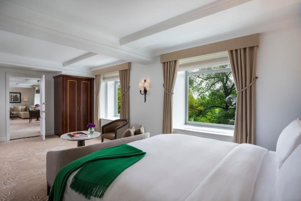 a bedroom with a large bed and a large window at The Ritz-Carlton New York, Central Park in New York