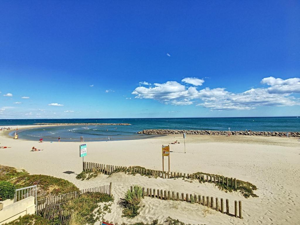 - une plage avec des personnes sur le sable et l'océan dans l'établissement Appartement mezzanine sur plage, rénové, wifi inclus - FR-1-715-32, à Mauguio