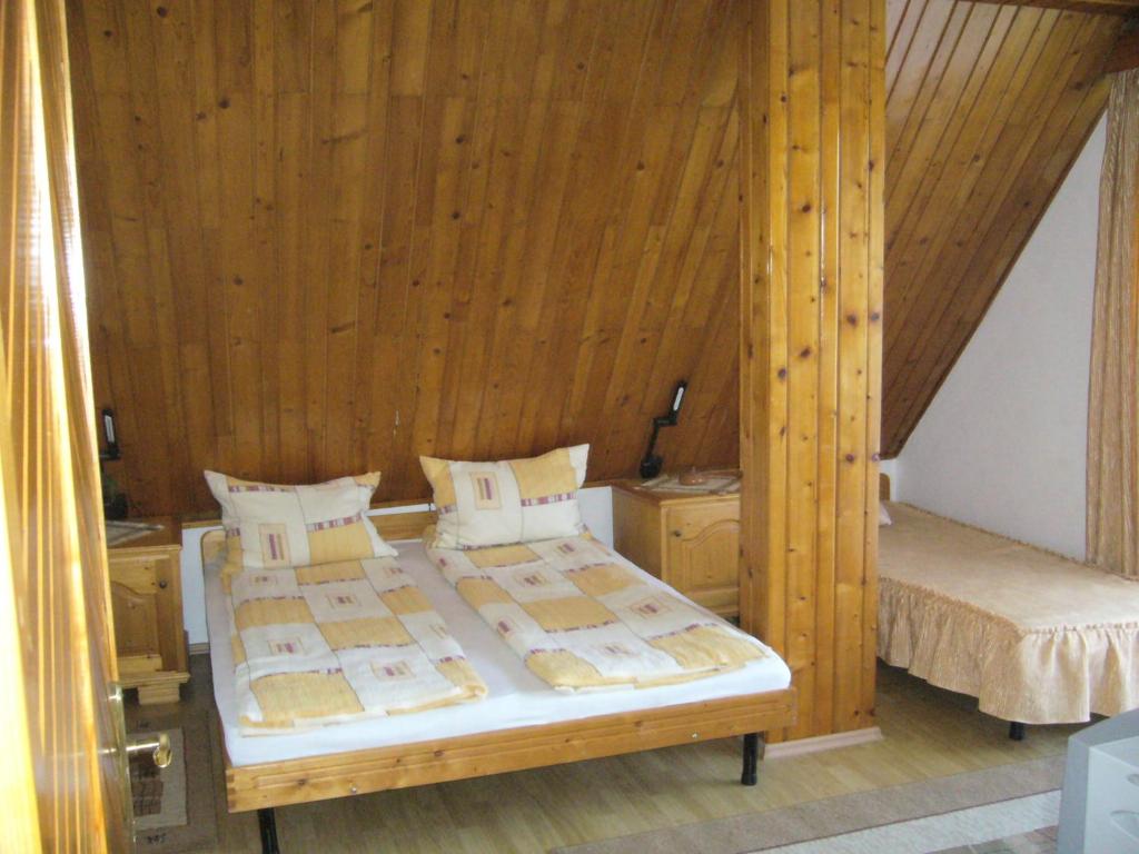 a bedroom with two beds with wooden walls at Csaki Vendeghaz in Sovata