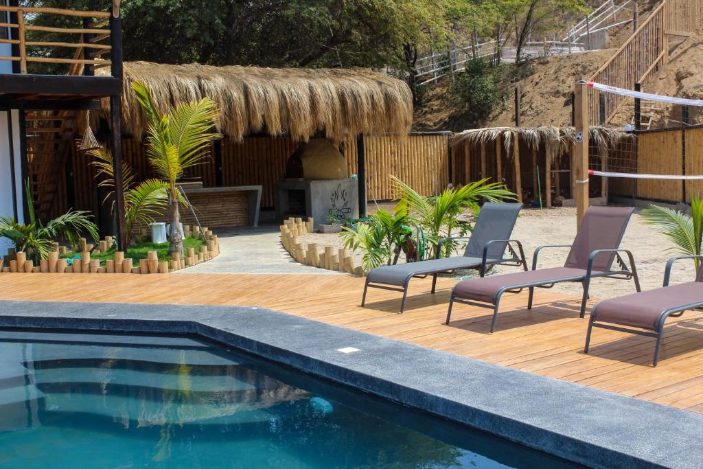 a swimming pool with chairs next to a house at Northshore Point Zoritos in Caleta Grau