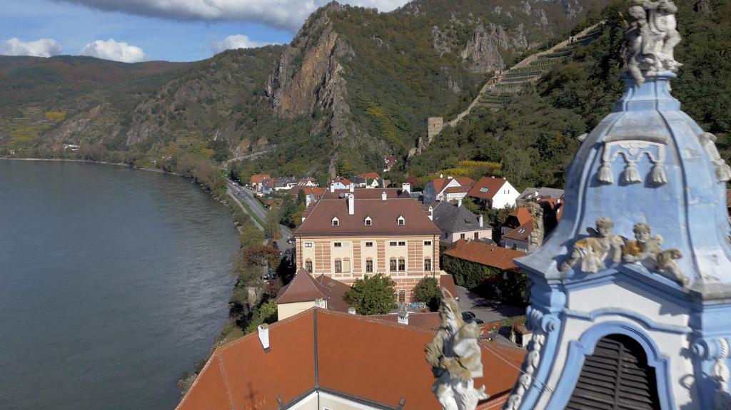 a view of a town and a river with a mountain at Hotel Schloss Dürnstein in Dürnstein
