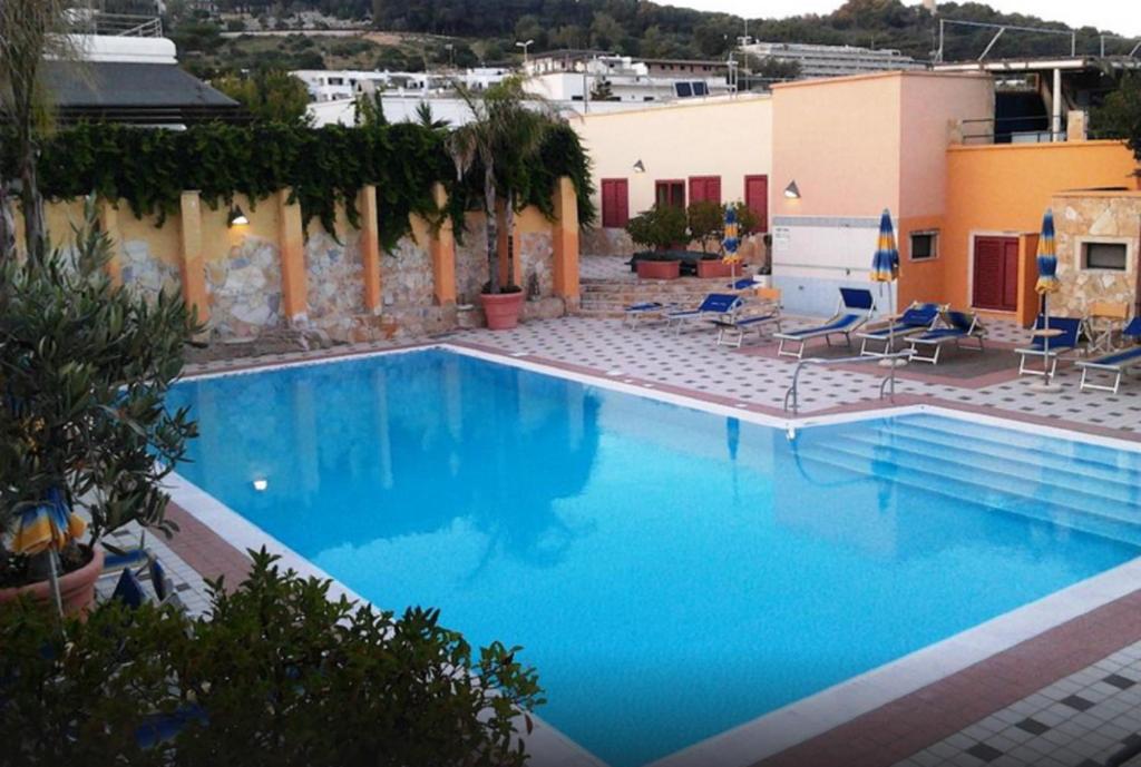 a large swimming pool with blue water in a resort at Hotel Le Macine in Santa Cesarea Terme