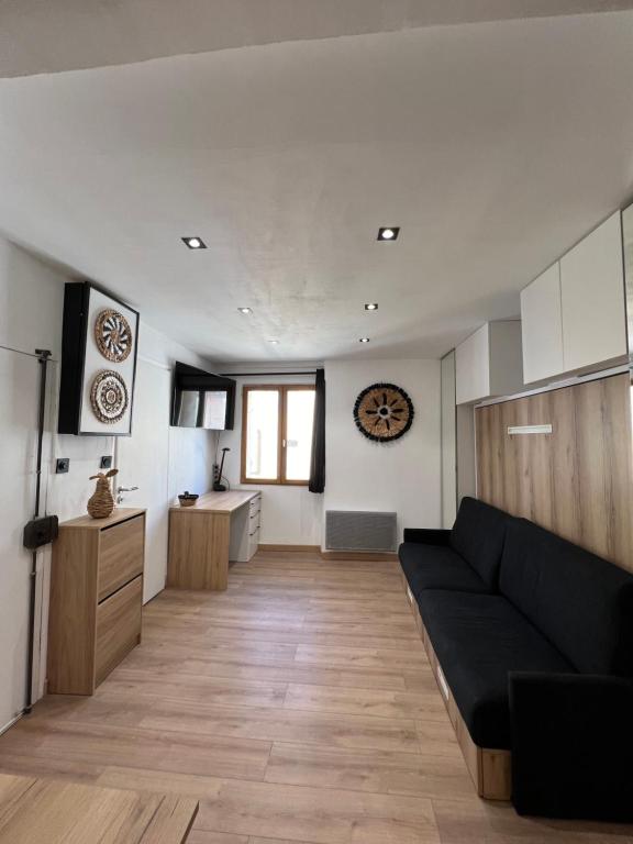 uma sala de estar com um sofá preto e uma cozinha em Studio Contemporain, À Deux Pas de la Mer à La Ciotat ! em La Ciotat