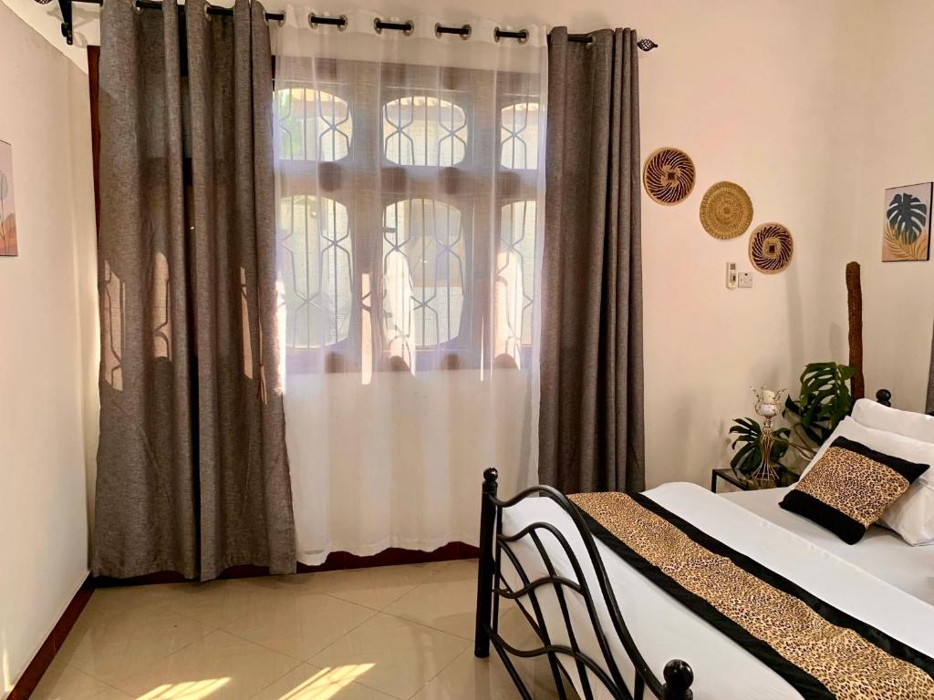 a bedroom with a bed and a window at GOLDEN TASTE REST HOUSE in Dar es Salaam