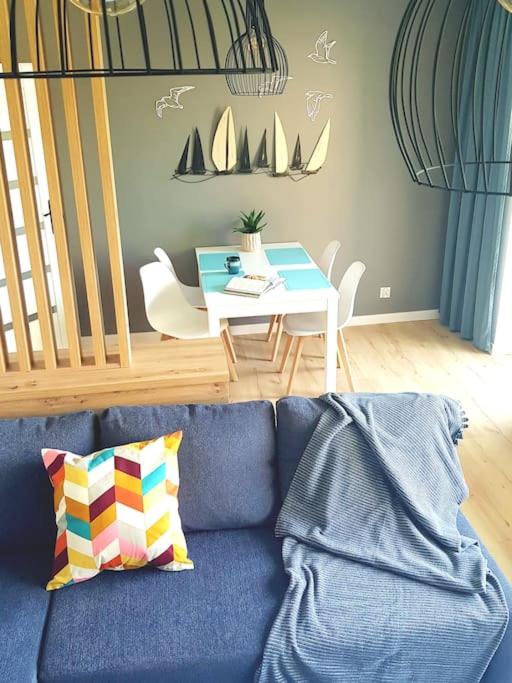a living room with a blue couch and a table at Spokojna Marina in Puck