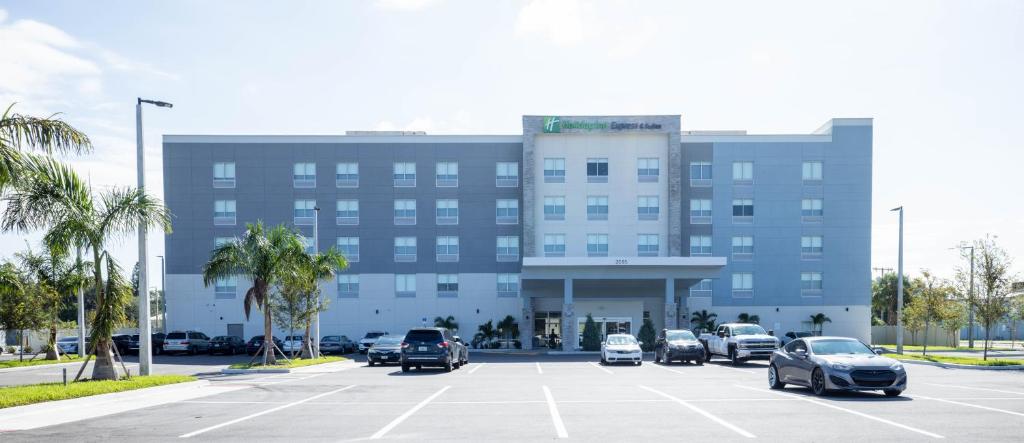 ein Parkplatz mit Autos vor einem Gebäude in der Unterkunft Holiday Inn Express & Suites Tampa Stadium - Airport Area, an IHG Hotel in Tampa