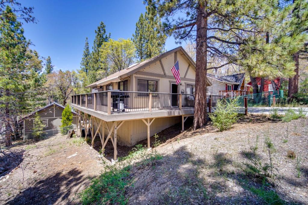 Uma casa com um alpendre e uma bandeira americana. em Rustic Big Bear Lake Cabin Retreat Near Skiing! em Big Bear Lake