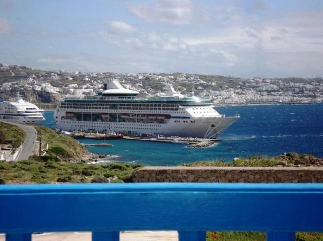 a cruise ship is docked in a harbor at Panorama Hotel in Agios Stefanos