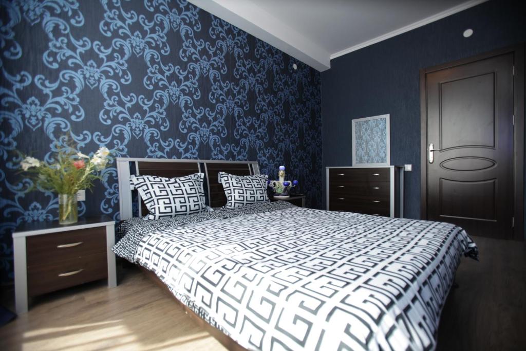 ein Schlafzimmer mit einem Bett und einer blauen Wand in der Unterkunft Mia B&B Tbilisi in Tbilisi City