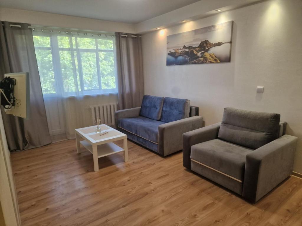 een woonkamer met een bank, een stoel en een tafel bij Butas 34 in Šiauliai