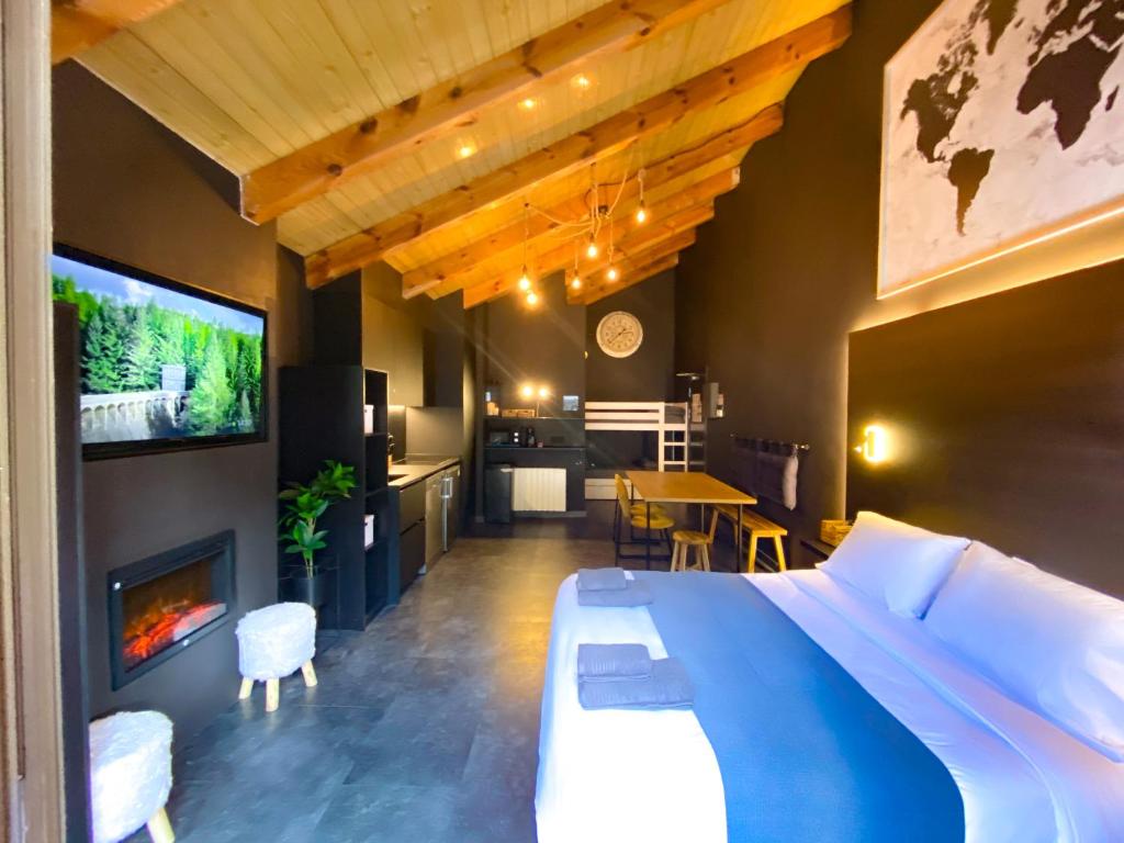 a bedroom with a bed and a fireplace and a kitchen at Modern Black Studio Penthouse En Valle De Incles - Parking Gratis in Canillo