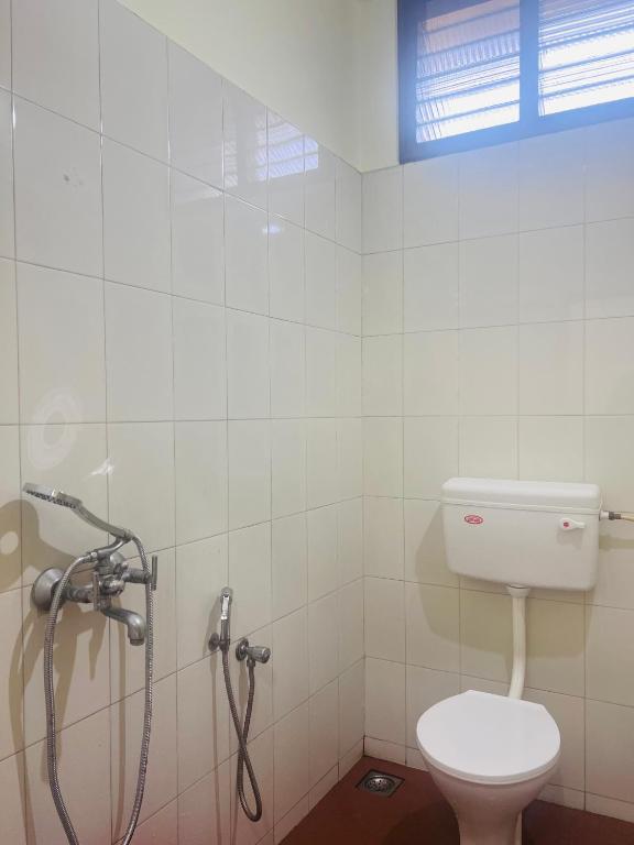 a bathroom with a shower and a toilet in it at Hotel Sunday - Townhouse Club Airport Trivandrum in Trivandrum