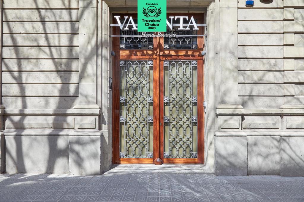 una puerta de madera en un edificio con un cartel en Vasanta powered by Sonder, en Barcelona