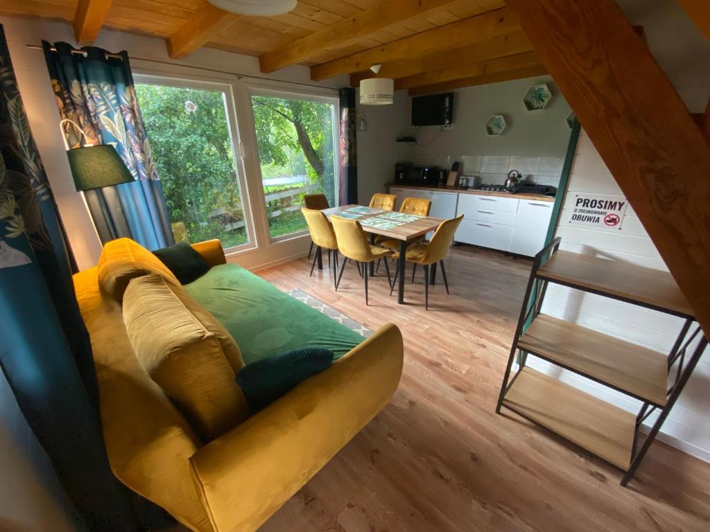 ein Wohnzimmer mit einem Sofa und einem Tisch in der Unterkunft Domki że Hej Bieszczady in Ustrzyki Dolne