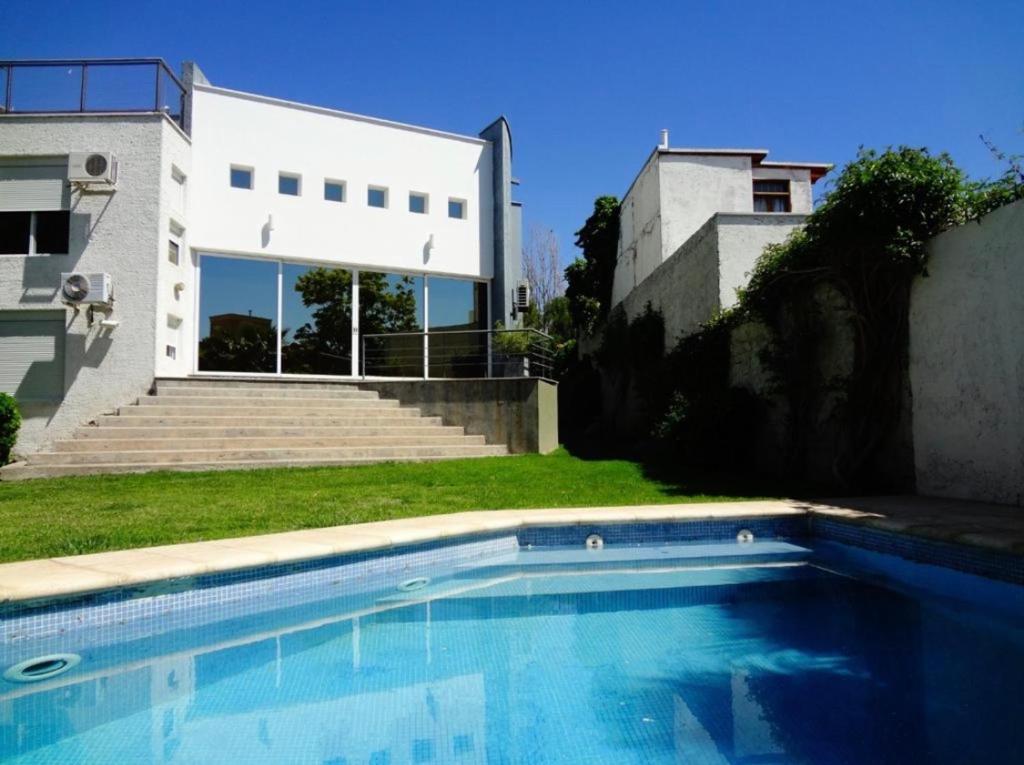 a swimming pool in front of a house at Casa en bonito barrio residencial - Ciudad in El Challao