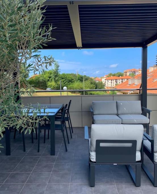 a patio with chairs and a table and a table and chairs at Atico con espléndida terraza in Comillas