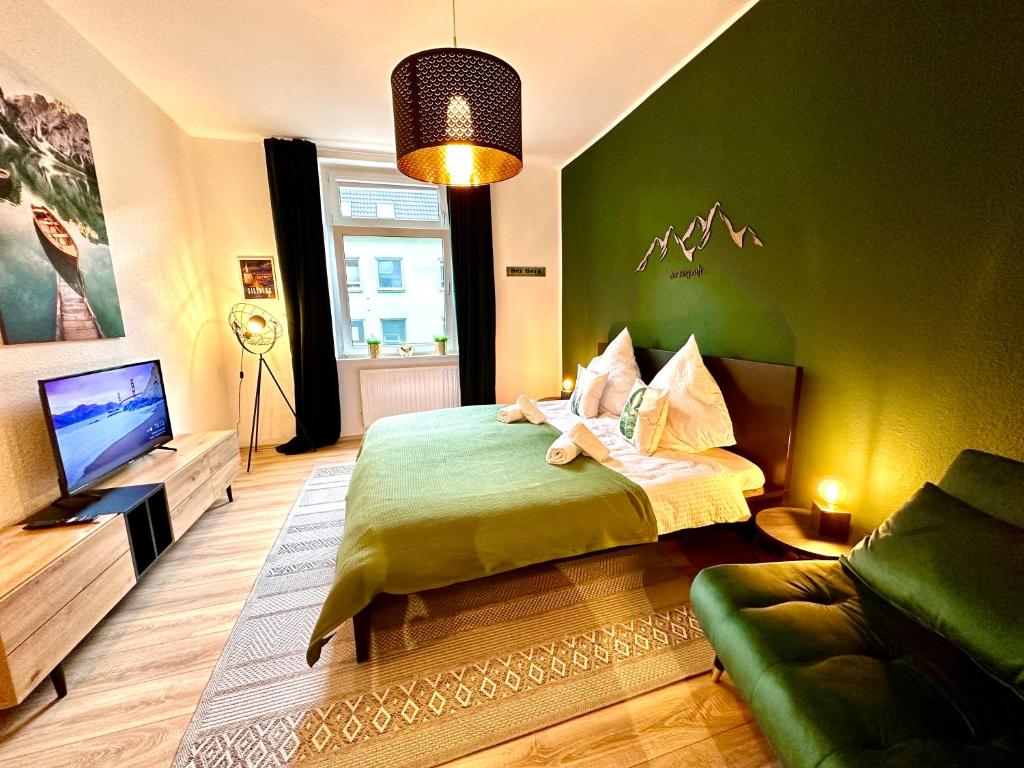 een groene slaapkamer met een bed en een televisie bij Das Berg Apartment Rüttenscheid, Netflix, nahe Messe, Klinikum in Essen