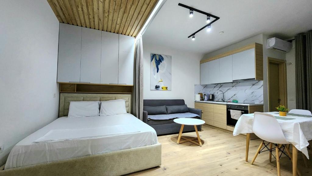 Cet appartement comprend une chambre avec un lit et une table ainsi qu'une cuisine. dans l'établissement Avalona Apartment 1, à Vlorë