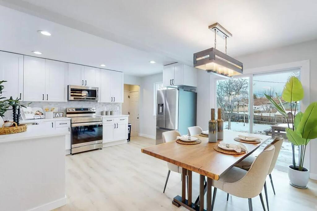 a kitchen with a wooden table and white cabinets at House of Vibes - Dog Friendly in Denver