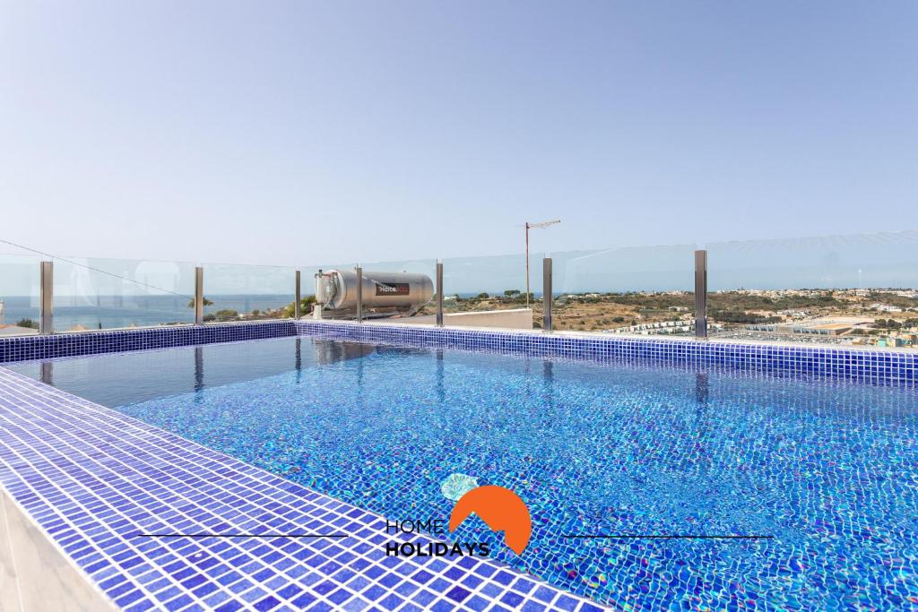 a swimming pool with an umbrella in the water at #078 Prestige Villa by Home Holidays in Páteo
