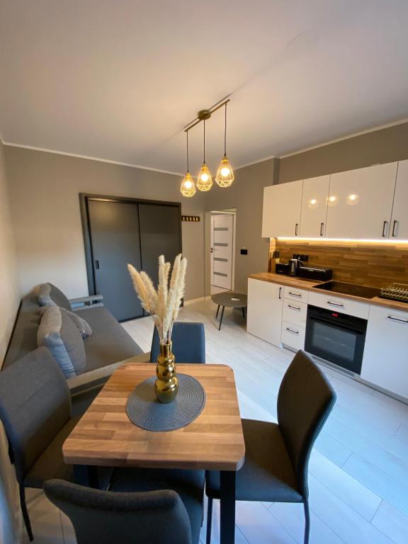 cocina y sala de estar con mesa y sillas. en Apartament Jarosław en Jarosław