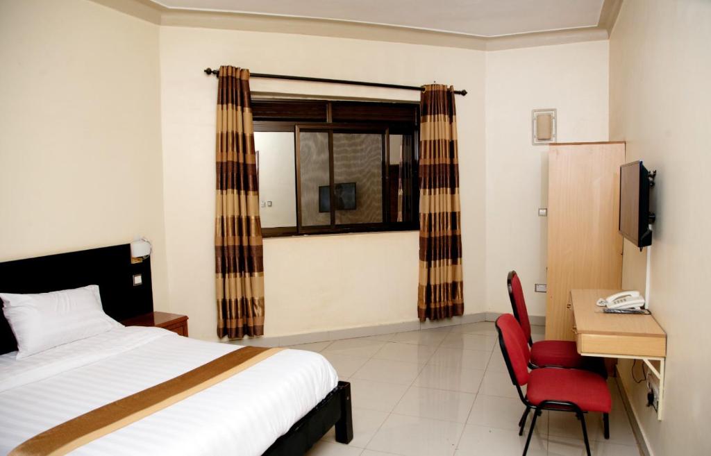 Postel nebo postele na pokoji v ubytování Ubuntu Palace Hotel Kampala